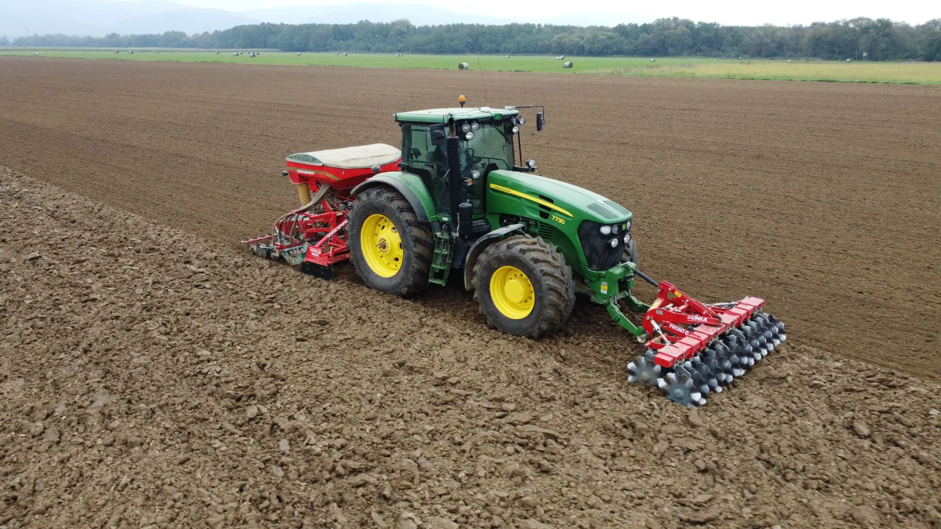 Traktor sa sijačicom tijekom sjetve na oranici